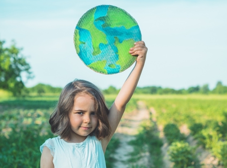 young girl lifting up earth picture